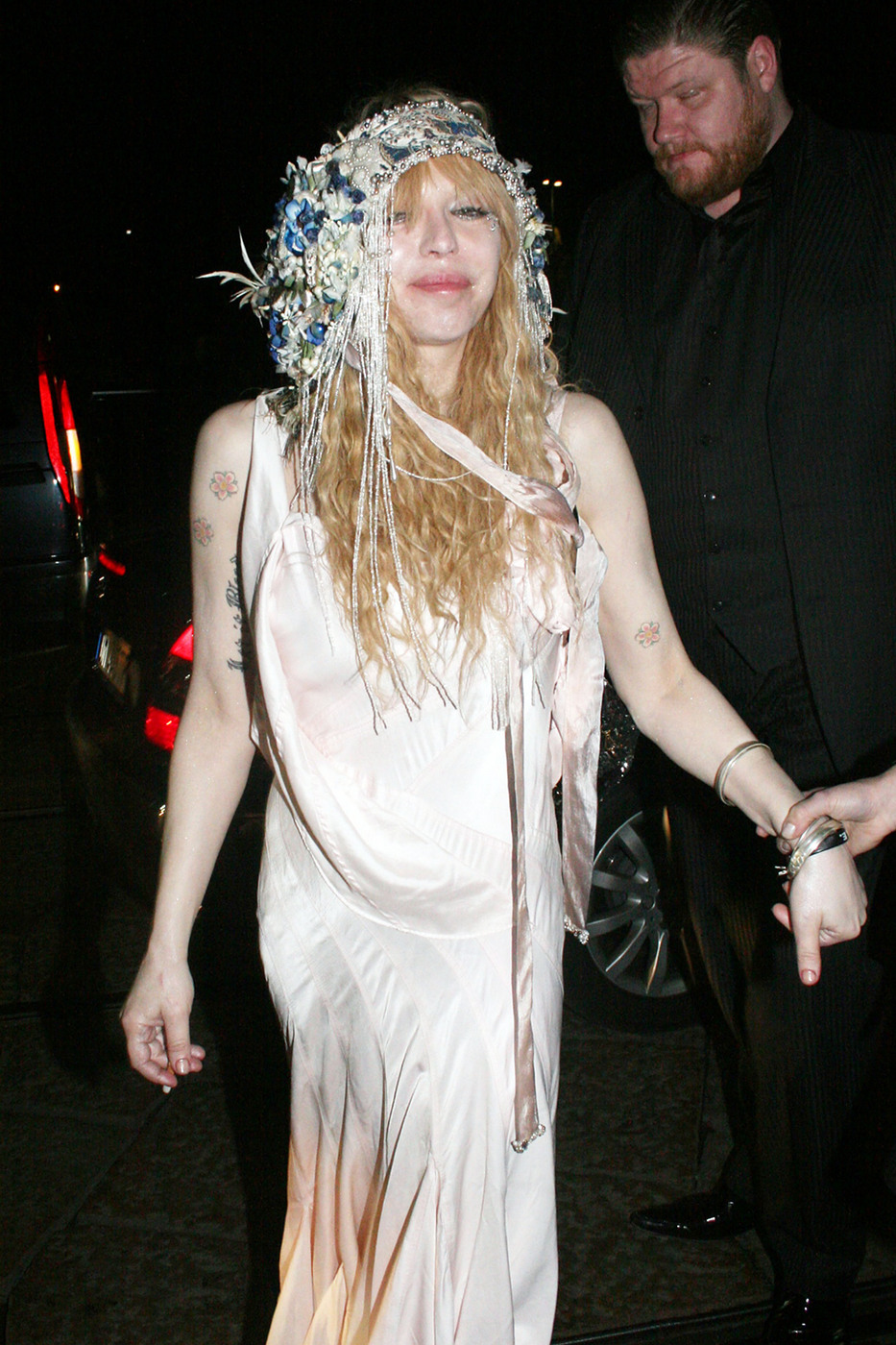 Courtney Love, wearing a long, flowing dress, takes part in the excitement surrounding Milan's Fashion Week