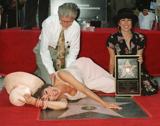 Latino entertainer Rita Moreno lays down next to h