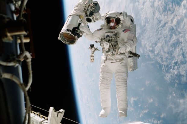 Astronaut William (Bill Mcarthur Appears Suspended Over The Blue And White Earth Octobe