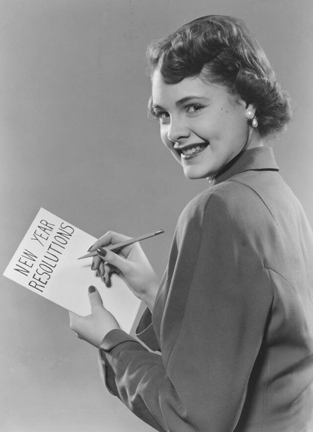 Young Woman Writing Her New Year Resolutions