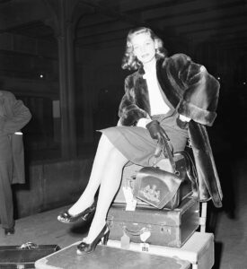 Lauren Bacall Sitting On Her Luggage